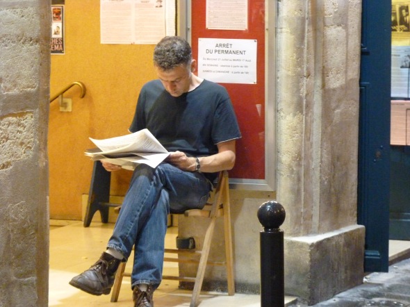 Homme lisant devant un panneau "arrêt du permanent", cinéma