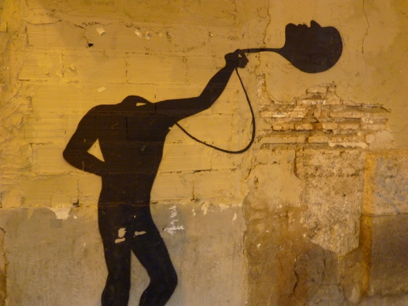 Silhouette peinte sur un mur tenant sa tête au bout d'un fil comme un ballon gonflé à l'hélium