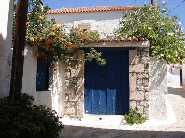 porte grecque, bleue, surmontée de jasmin et chèvrefeuille